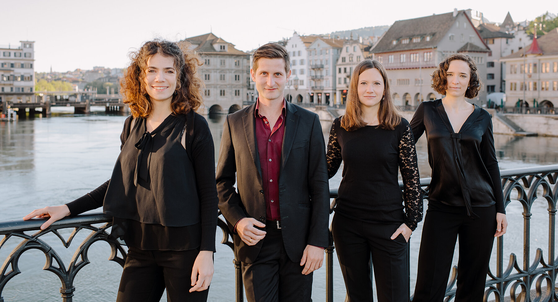 The Belenus Quartett on a bridge over the Limmat river, with Zurich's old town behind